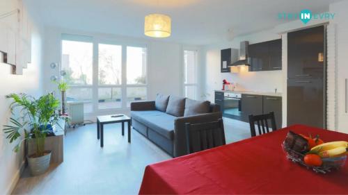 un salon et une cuisine avec un canapé et une table dans l'établissement Stay In Evry, Évry-Courcouronnes