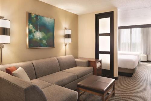 a living room with a couch and a bed at Hyatt Place Chicago Hoffman Estates in Hoffman Estates