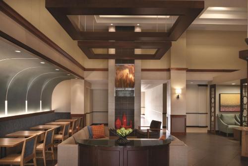 a lobby of a hotel with a bar and chairs at Hyatt Place Chicago Hoffman Estates in Hoffman Estates