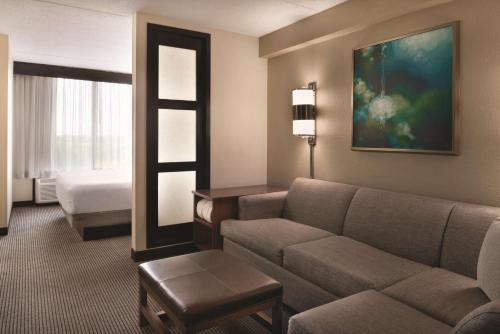 a hotel room with a couch and a bed at Hyatt Place Chicago Hoffman Estates in Hoffman Estates