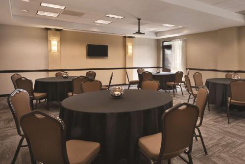 a conference room with tables and chairs and a screen at Hyatt Place Chicago Hoffman Estates in Hoffman Estates