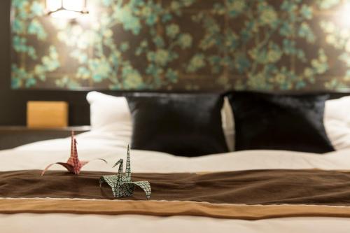 a bed with two small figurines on top of it at Tsuki no Yado Kaguya in Kawagoe