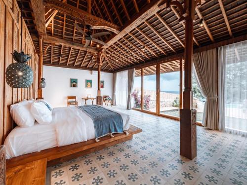 a bedroom with a bed and a large window at Villa Victoria Nusa Penida in Nusa Penida