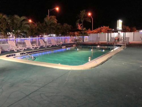 a swimming pool at night with chairs around it at Sunshine Inn & Suites Venice, Florida in Venice