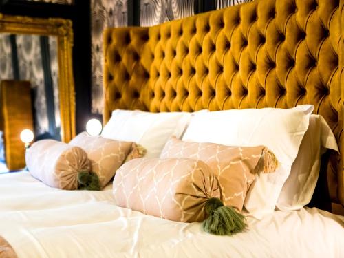 a bed with white pillows and a yellow headboard at Luxury Travel Emporium YO1 - Exquisite 400 Year Old, City Centre Townhouse in York