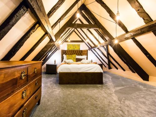 a attic bedroom with a bed and a dresser at Maison Parfaite YO1 - Exquisite 400 Year Old, City Centre Townhouse in York