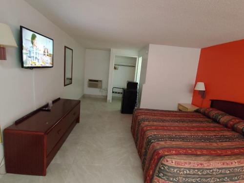 um quarto de hotel com uma cama e uma televisão de ecrã plano em Relax Inn Silver Springs em Silver Springs