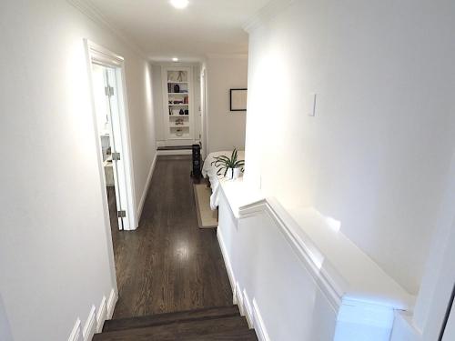 a hallway with white walls and a white stair case at Garden Level Flat in 1885 Queen Anne Victorian Cottage in Alameda in Alameda