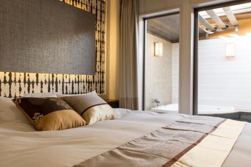 a bedroom with a large white bed and a window at Tsuki no Yado Kaguya in Kawagoe