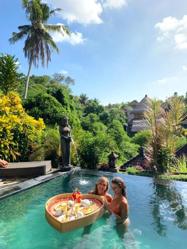 two women in the swimming pool at a resort at Kukuh House Ubud in Ubud