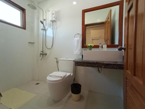 a bathroom with a toilet and a sink and a mirror at San Pedro Country Farm Resort and Event Center Inc in Cantilan