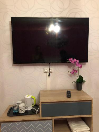 a flat screen tv hanging on a wall at Chambres privées Calais Ferry-Port-Place d'armes in Calais
