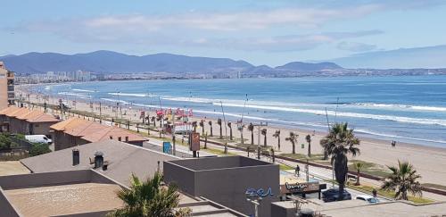 ラ・セレナにあるDepartamentos La Serena Vistaの海と建物のあるビーチの景色を望めます。