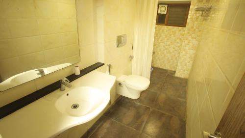 a bathroom with a sink and a toilet at Hotel Vijayetha in Nāgercoil