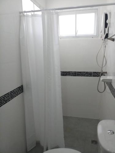 a bathroom with a white shower curtain and a window at Origin hua hin poolvilla in Hua Hin