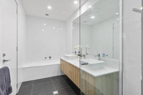 a white bathroom with a sink and a tub at Stunning Main Beach Location- Anglesea in Anglesea