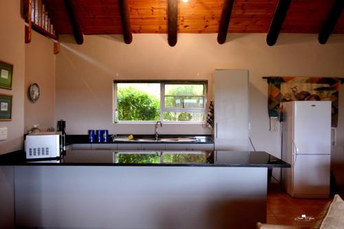 a kitchen with a sink and a refrigerator at Kududu Guest House in Addo