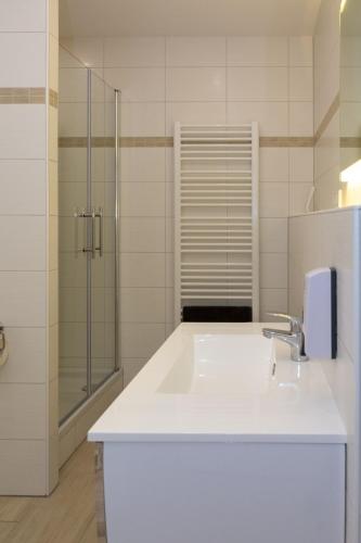 a white bathroom with a sink and a shower at Zimmervermietung Dietzenbach in Dietzenbach