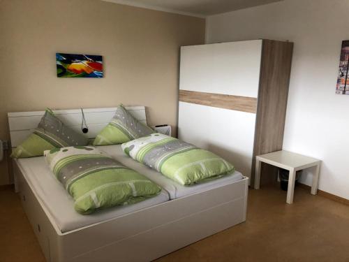 Bett mit grünen Kissen auf einem Zimmer in der Unterkunft Töff - Töff in Willingen