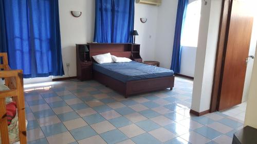 蒙舒瓦西The Impala Mauritius holiday and leisure flat Mon Choisy -Trou aux biches的一间带床和蓝色窗帘的卧室