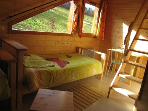 ein kleines Schlafzimmer mit einem Bett und einem Fenster in der Unterkunft Les Myrtilles in Le Bonhomme