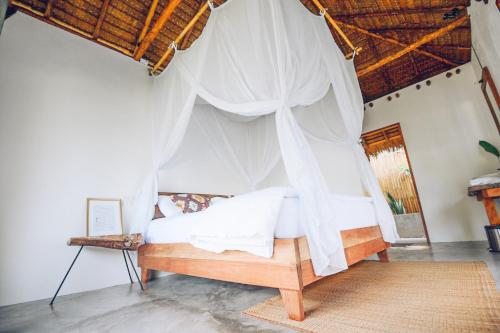 a bedroom with a bed with white mosquito nets at Inhale @ Hill in Koh Mook