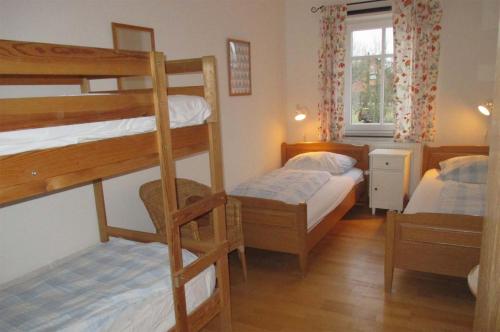 a bedroom with two bunk beds and a window at Hof Faasel - Bauernhofurlaub an der Ostsee in Grömitz