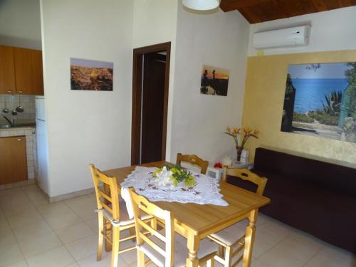 a kitchen and dining room with a wooden table and chairs at La Perla di Sicilia in Marina di Modica