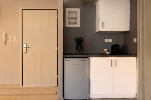 uma cozinha com armários brancos e uma máquina de lavar louça ao lado de uma porta em City Vibes, a KalamataStay Property em Kalamata
