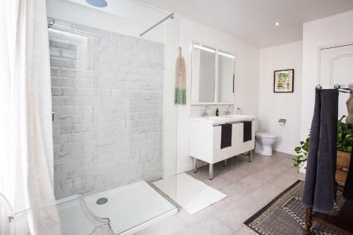 a white bathroom with a shower and a sink at Carcassonne Townhouse in Carcassonne