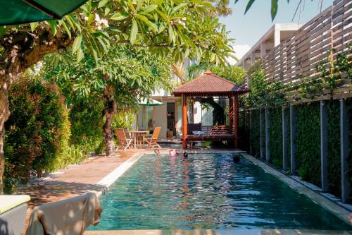 einen Pool mit Pavillon und Enten im Wasser in der Unterkunft D'sawah Villa in Tanah Lot