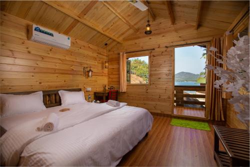 a bedroom with a large bed in a wooden cabin at Ourem Palace in Palolem