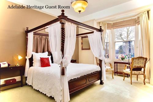 a bedroom with a canopy bed and a window at Kurrajong House in Launceston