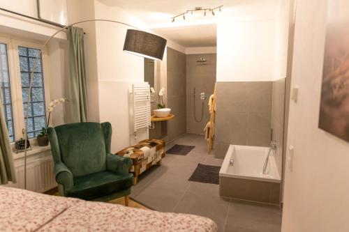 a bathroom with a green chair and a tub at Schlossberg - Apartment in Graz