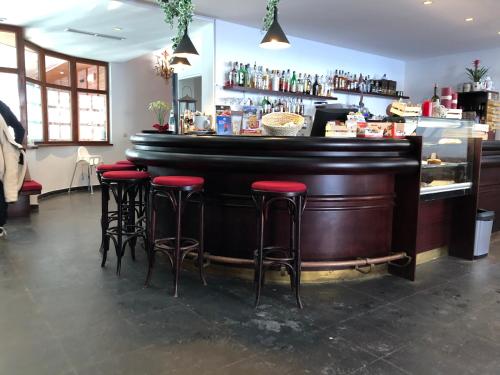 a bar with red stools in a restaurant at Ploner villaggio Turistico in Dobbiaco
