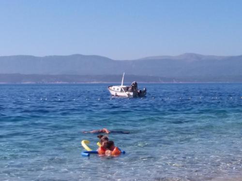 a group of people in the water with a boat at Center apartment Golden Ray in Bol
