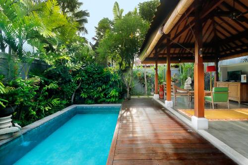 a swimming pool next to a house with a pavilion at Aradhana Villas by Ekosistem in Canggu