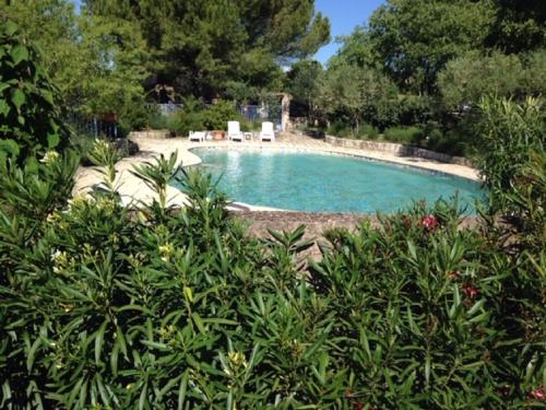 - une piscine avec deux chaises dans la cour dans l'établissement Location climatisée, piscine, animaux acceptés, jardin clôturé, parking, provence , wifi, à Lorgues