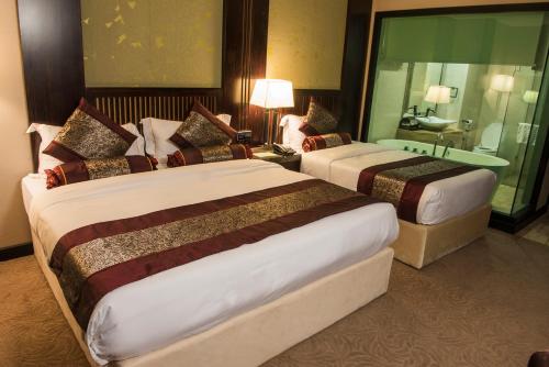 a hotel room with two beds and a bathroom at Royale Signature Hotel in Alor Setar