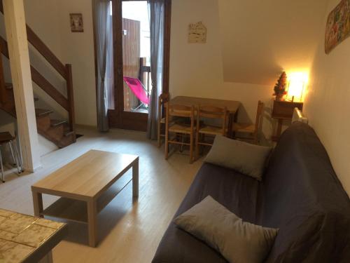 un salon avec un canapé et une table dans l'établissement Duplex T2 Cabine aux pieds du télécabine avec parking, à Luchon
