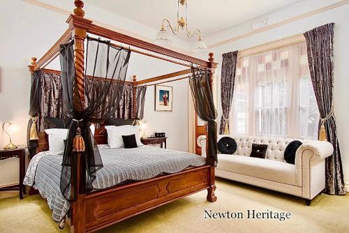 a bedroom with a four poster bed and a couch at Kurrajong House in Launceston