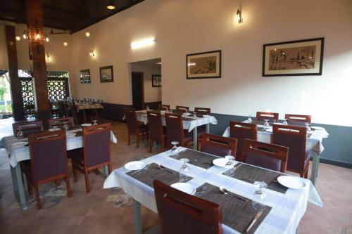 a dining room with tables and chairs in a restaurant at GREEN PLANET HOTEL in Mattanūr