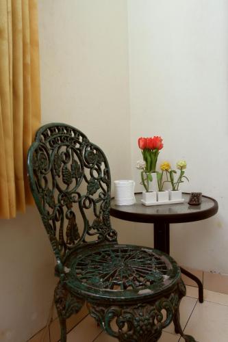 a table with a chair and a table with flowers at Unique Guesthouse in Bandung