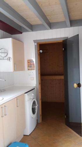 a kitchen with a washing machine and a door to a closet at Marinapark Scharmützelsee in Wendisch Rietz