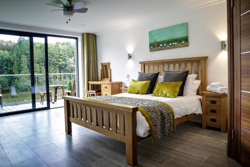 a bedroom with a bed and a large window at Canada Lodge and Lake in Creigiau