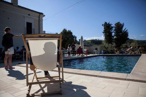 a person standing next to an easel next to a pool at Baldovino b&b in Villamagna