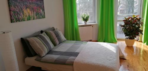 - une chambre avec des rideaux verts et un lit dans un dortoir dans l'établissement Zielone Studio, à Oborniki Śląskie