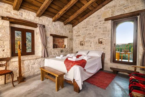 a bedroom with a bed in a stone room at Kamihis Farm House Experience in Zarós