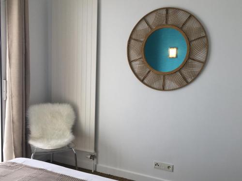 a mirror on a wall next to a chair at Escapade au bord du lac du Bourget in Le Bourget-du-Lac