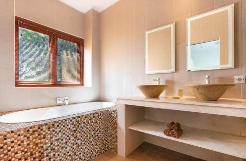 y baño con bañera y lavamanos. en Puri Temple Villa, en Canggu